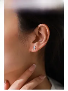 Primo piano di eleganti orecchini a lobo in argento S925 con pietra di luna su modella