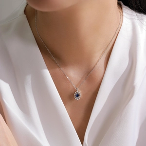 S925 sterling silver sunflower necklace with deep blue sapphire on a female model