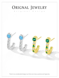 Gros plan de boucles d'oreilles C en argent S925 avec zircons turquoise et émeraude