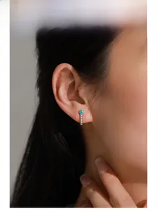 Détail du clou d'oreille en argent S925 avec turquoise et zircones blanches sur l'oreille