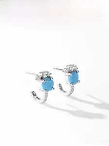 Dettaglio di orecchini a C in argento S925 con turchese e pietre di zircone lucenti