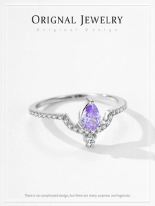 Dettaglio anello con zircone viola a goccia e fascia a V con pavé di diamanti brillanti