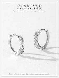 Detail of S925 sterling silver hoop earrings with a bow shape and micro-pave zircons