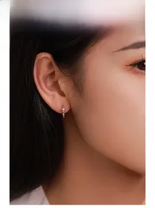 Close-up of S925 silver bow earrings with sparkling cubic zirconia on a model