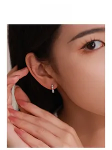 Detail of silver bow earrings with sparkling micro-diamonds on model's earlobe