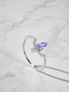 Dettaglio anello con gemma viola a goccia e incisione S925 su fascia in argento
