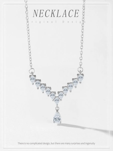 Macro shot of V-shaped S925 sterling silver necklace with pear-cut sparkling zircons