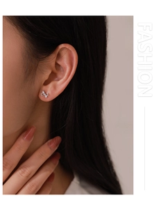 Close-up of model wearing small silver bow earrings with sparkling micro-pave cubic zirconia