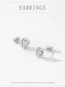 Detail of S925 silver flower earrings with hollow petals and a sparkling cubic zirconia stone