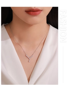 Detail of S925 silver V-shaped necklace with teardrop pendant and sparkling diamonds