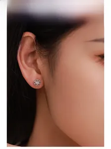 Close-up of elegant S925 sterling silver hollow flower stud earrings worn by a model