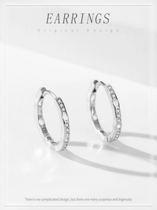 Macro detail of S925 sterling silver hoop earrings with cubic zirconia and dotted patterns