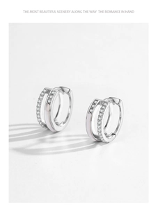 Detail of S925 silver Mobius earrings with white enamel and sparkling cubic zirconia pavé