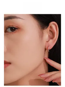Macro detail of minimalist S925 silver hoop earrings with pave cubic zirconia on model