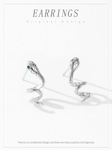 Détails de boucles d'oreilles serpent en argent avec yeux verts et texture d'écailles