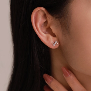 Elegant S925 sterling silver bow knot earrings with sparkling crystals worn by model