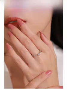 Close-up of sparkling 925 silver heart ring with pave diamonds on model's finger