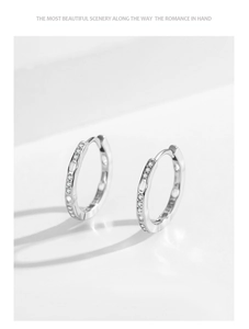 Macro shot of S925 sterling silver hoop earrings with zircon stones and wavy edge details