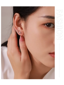 Détail macro de la boucle d'oreille serpent en argent 925 portée sur le lobe