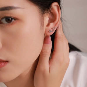 Boucles d'oreilles serpent en argent 925 avec gemme verte sur un modèle élégant de profil