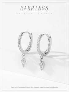 Detailed macro view of S925 sterling silver earrings with diamond-shaped zircon pendants