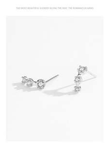 Macro detail of S925 sterling silver stamp and three-stone zircon stud earrings