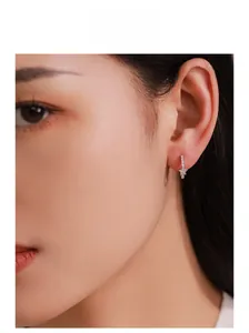 Close-up of S925 sterling silver star hoop earrings with micro-set cubic zirconia on model