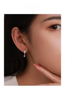 Close-up of S925 sterling silver drop earrings with pear-shaped cubic zirconia on model