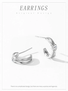 Close-up of S925 silver half-hoop earrings featuring heart-shaped zircon and pavé detail
