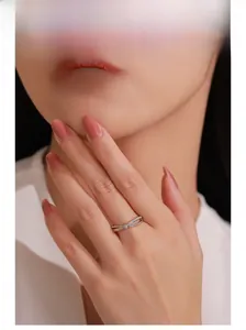 Détail d'une bague en argent 925 avec cœur entrelacé et zircons brillants sur le doigt
