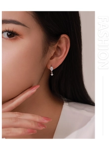 Close-up of S925 sterling silver pear-shaped zircon earrings worn by a female model