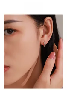 Model wearing sterling silver geometric diamond hoop earrings with pavé setting