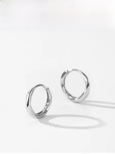 Macro shot of minimalist S925 sterling silver hoop earrings with twisted texture design