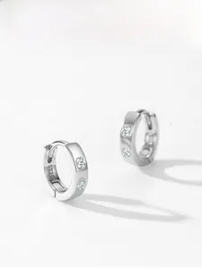 Détail macro de boucles d'oreilles créoles en argent 925 avec zircons et poinçon