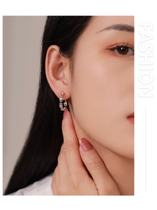 Gros plan de boucles d'oreilles chaîne en argent S925 avec zircons sur le mannequin