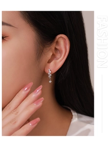 Close-up of 925 sterling silver drop earrings with star-like cubic zirconia crystals
