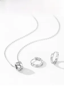 Macro shot of 925 silver necklace and earrings with geometric diamond cut and zircon stones