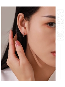 Close-up of 925 sterling silver hoop earrings with diamond accents and rhombus texture