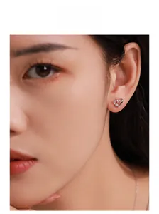 Detail of S925 sterling silver heart stud earring with micro-inlaid diamonds on model