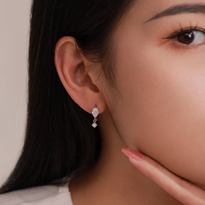 Elegant S925 sterling silver drop earrings featuring pear-cut zircon stones on a model