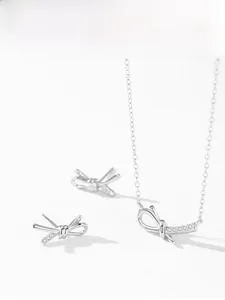Detailed view of silver bow-knot jewelry set with necklace and earrings in cubic zirconia