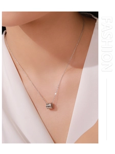 Close-up of S925 silver cylinder pendant necklace worn on a woman neck for elegance
