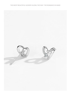 Macro detail of S925 sterling silver hollow heart stud earrings with sparkling zircons
