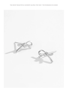 Detailed macro view of S925 sterling silver bow knot earrings with sparkling cubic zirconia