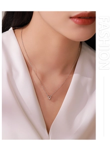Détail d'un collier en argent 925 avec cœurs entrelacés et zircon porté par un mannequin