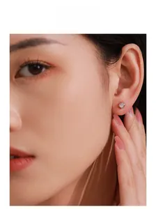 Close-up of minimalist S925 sterling silver square stud earring with a central zircon