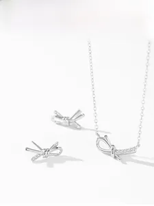 Macro detail of S925 silver bow pendant necklace and earrings with sparkling cubic zirconia