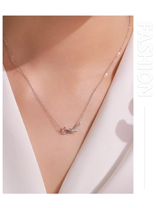 Close-up of S925 sterling silver knot pendant necklace with zircon stones on a model
