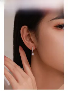 Gros plan d'un ensemble boucles d'oreilles et pendentif tournesol en argent S925