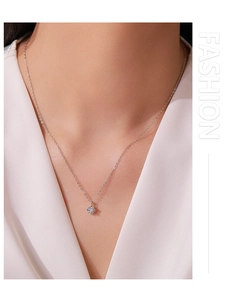 Close-up of S925 silver necklace with sparkling single diamond pendant on a female model